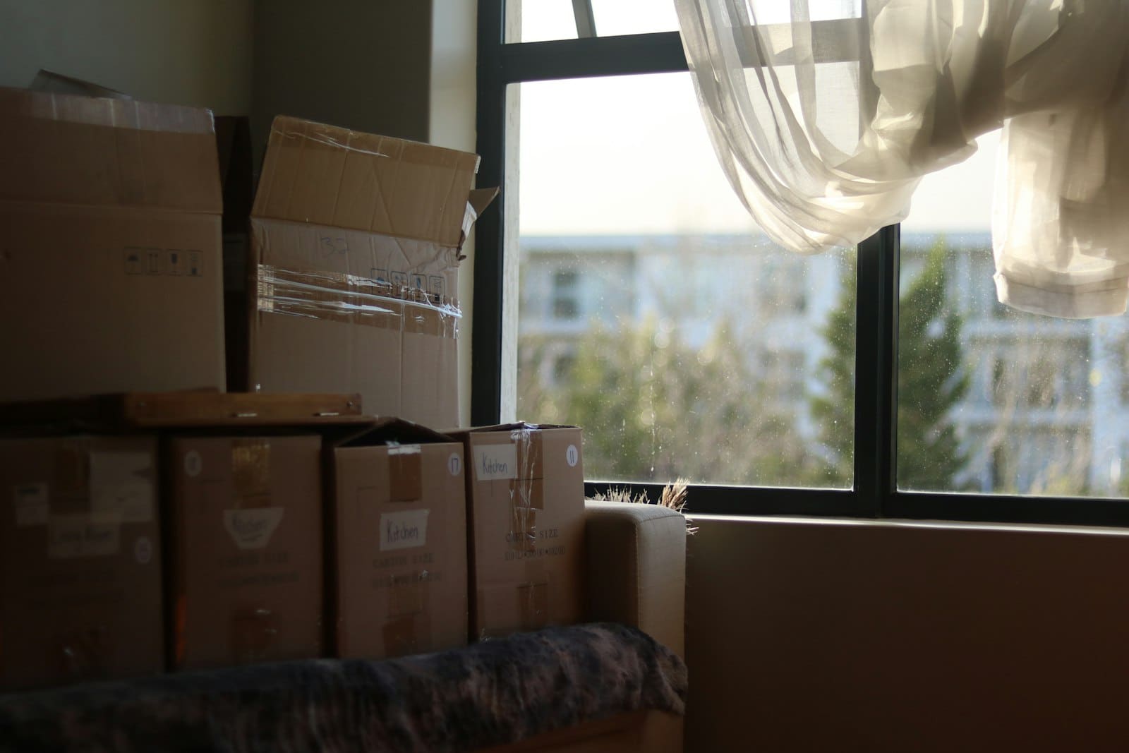 引っ越しの荷物が積まれた部屋のイメージ
